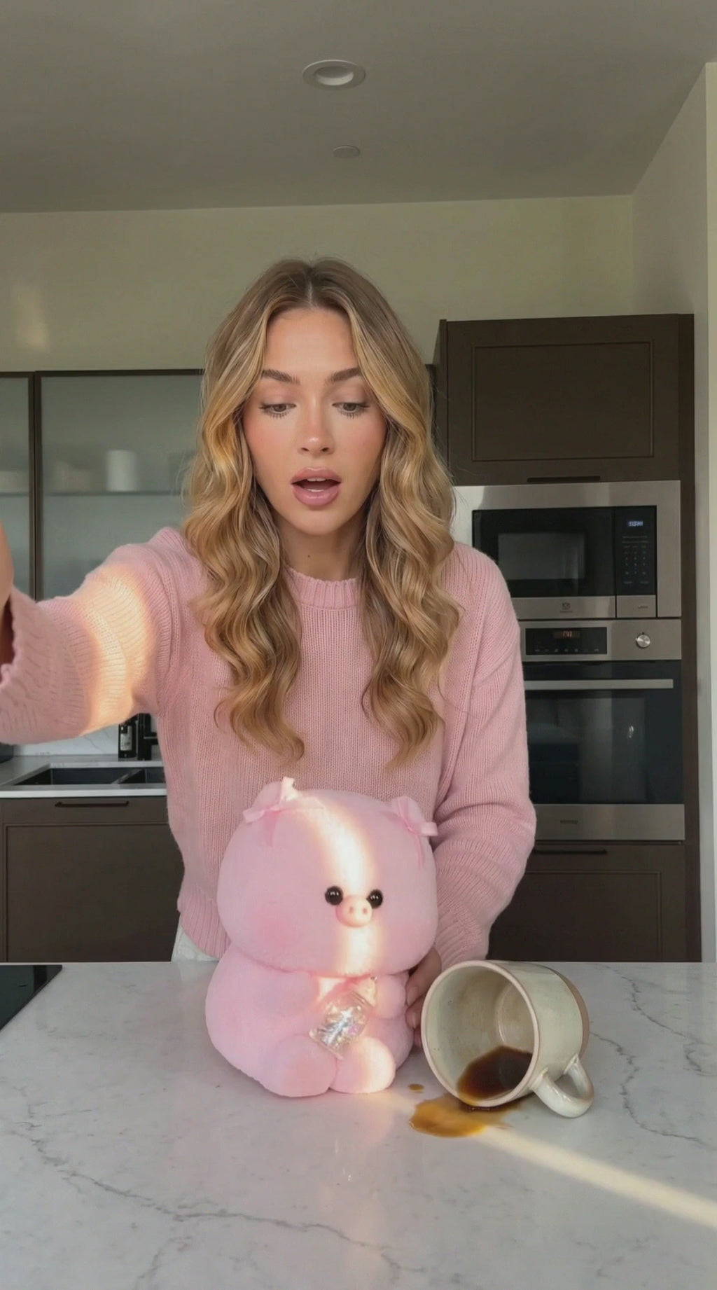 Pink piglet squishy toy being squeezed and slowly rebounding on a pink tabletop with pastel props.